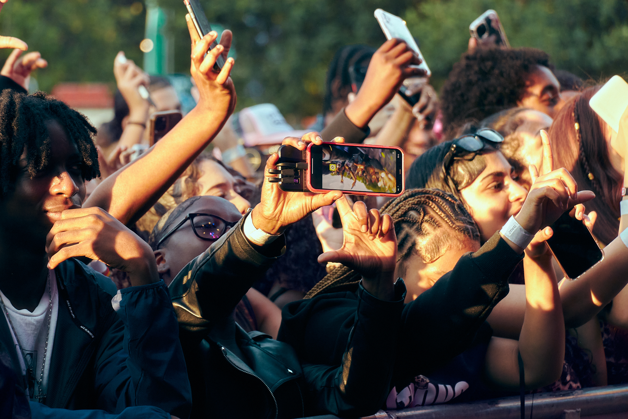 LIVE MUSIC - Performer on stage lights and crowd in front have their arms in the air.