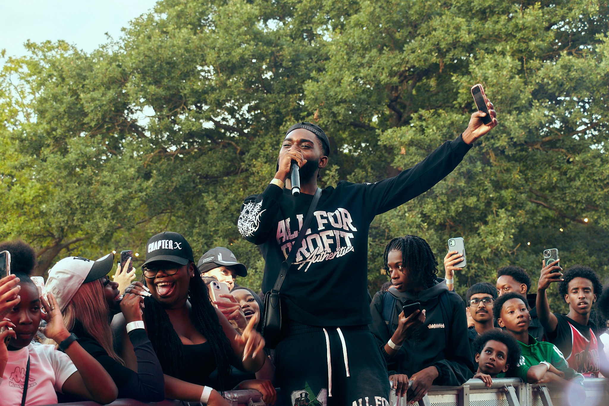 LIVE MUSIC - Performer on stage lights and crowd in front have their arms in the air.